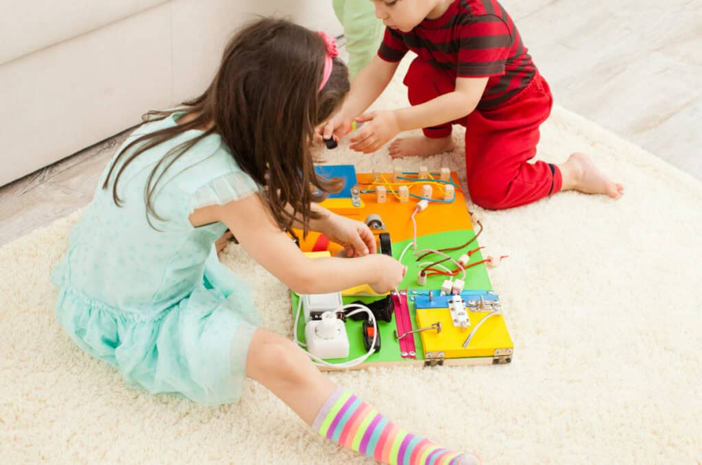 Children playing a Busy Board