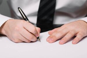 unrecognizable man writing in office