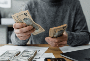 person holding money at a table