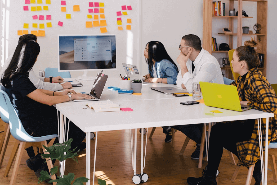A team meeting of marketing agency employees with laptops