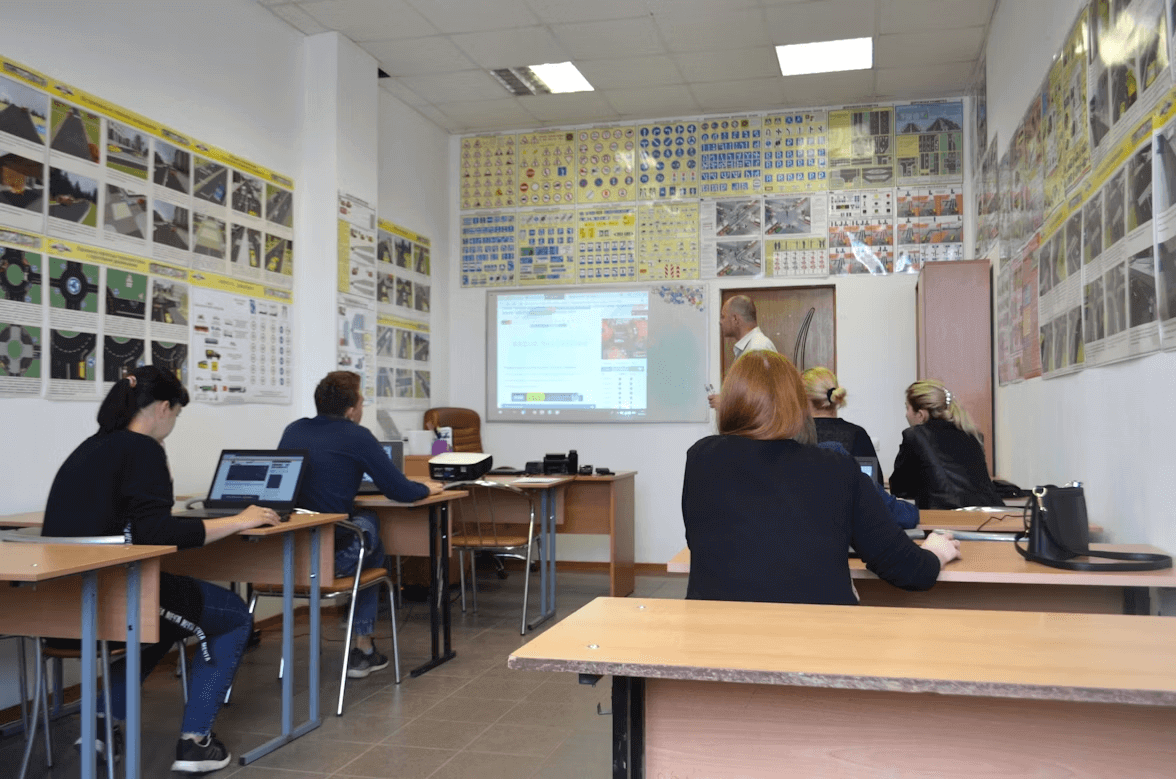 Students attending an online high school class with a projector