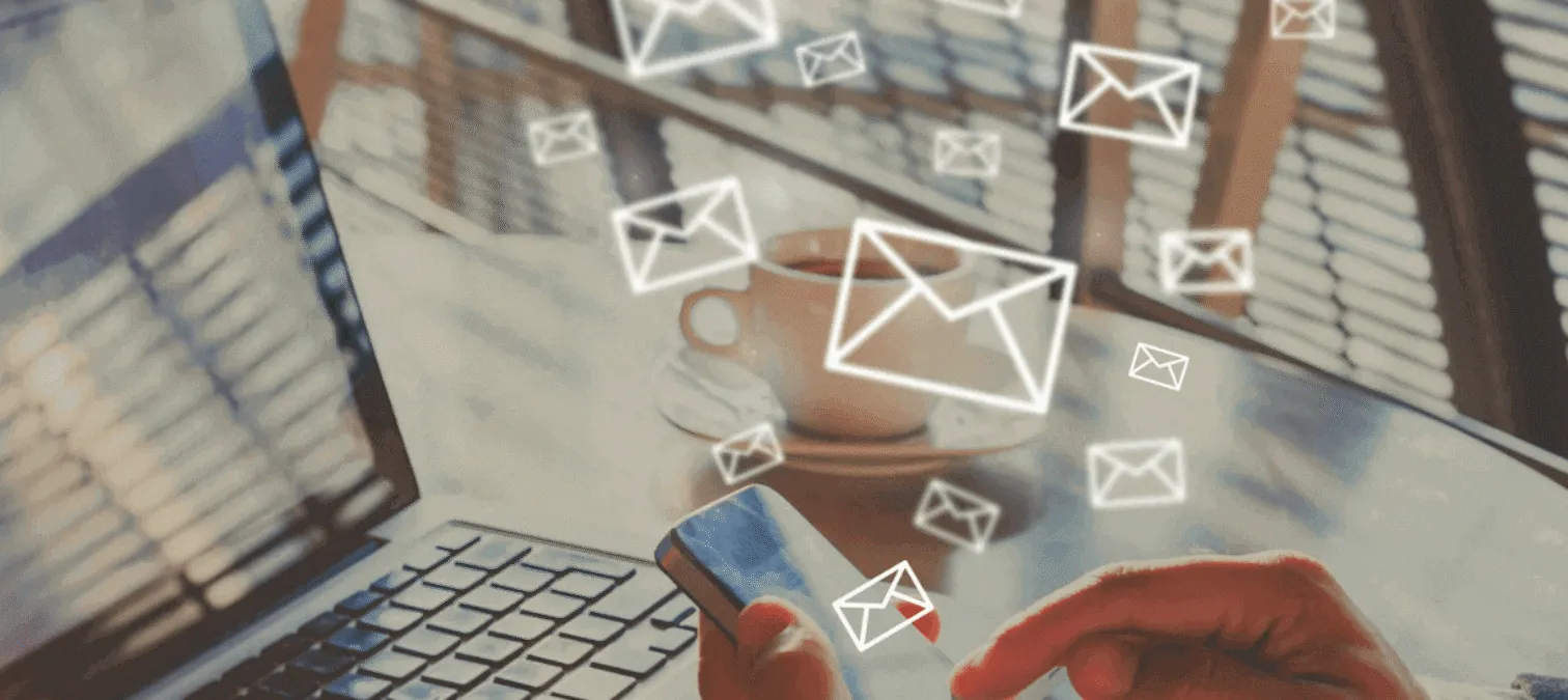 Person using laptop and phone for email personalization