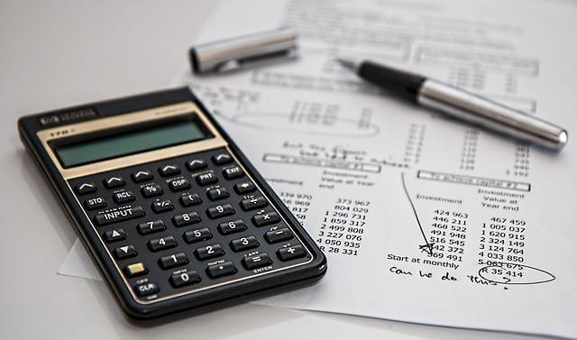 The Invisible Weight: Why Financial Minimalism is the Best Self-Care You’re Not Doing 3 Calculator on a pile of papers