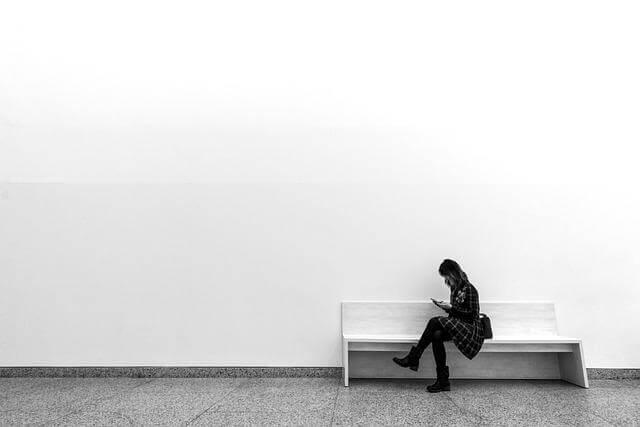 The Invisible Weight: Why Financial Minimalism is the Best Self-Care You’re Not Doing 2 Woman sitting on a white bench in